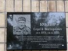 Меморіальна дошка на честь Козиря Сергія Вікторовича (10.07.1974 - 29.04.2015), старшого сержанта Збройних сил України, який загинув при виконанні військового обов'язку під час захисту територіальної цілісності та недоторканності України